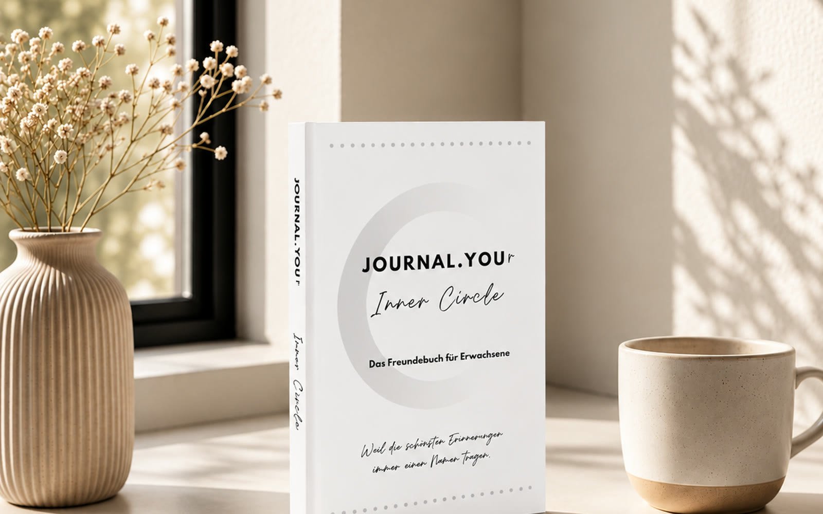 Journal.You Inner Circle auf einem Fensterbrett mit Vase und Tasse
